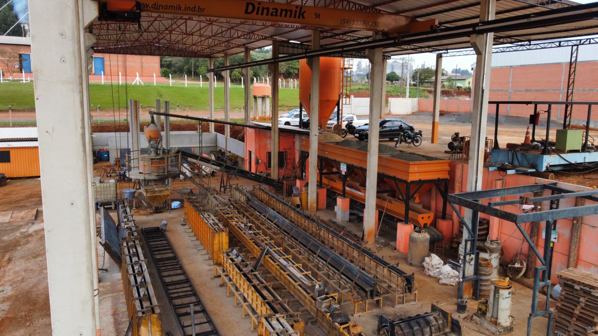 Pistas de concretagem, formas metálicas e ponte rolante.